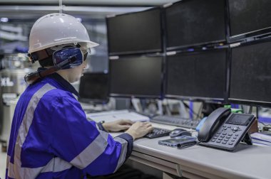 Tayland 'da, ameliyathanede çalışan Asyalı mühendis kask takıyor, özenle ve sabırla çalışıyor, hidrojen tankının valf düzenleyicisini kontrol ediyor..