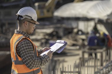 Köprü inşaatında çalışan inşaat mühendisi inşaat mühendisi, inşaat mühendisi denetleme işi, Foreman inşaat sahasındaki işi denetliyor.