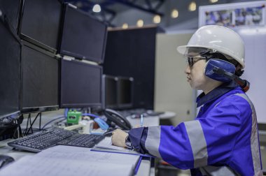 Tayland 'da, ameliyathanede çalışan Asyalı mühendis kask takıyor, özenle ve sabırla çalışıyor, hidrojen tankının valf düzenleyicisini kontrol ediyor..