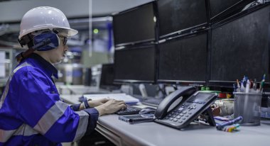 Tayland 'da, ameliyathanede çalışan Asyalı mühendis kask takıyor, özenle ve sabırla çalışıyor, hidrojen tankının valf düzenleyicisini kontrol ediyor..