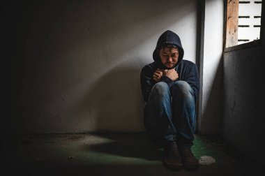 Asyalı bir bağımlı, ıssız bir yerde uyuşturucu bağımlısı, bu dünyada kendini yalnız hisseden bir keş, odanın bir köşesinde oturan üzgün bir genç, insanlar stresli ve depresyondalar.