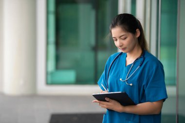 Klinikte çalışan genç Asyalı hemşire, bir hastanede doktor portresi.