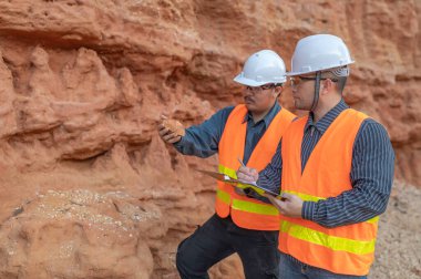 Benimkini araştıran bir jeolog, madenciler mineralleri aramak için toprak örnekleri topluyor..