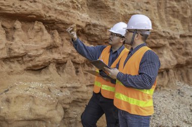 Benimkini araştıran bir jeolog, madenciler mineralleri aramak için toprak örnekleri topluyor..