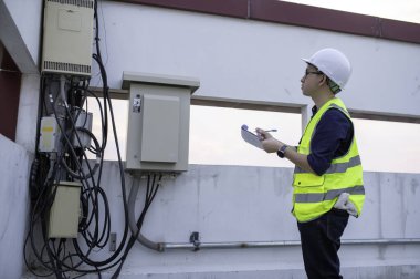 Telekomünikasyon mühendisleri 5G cep telefonu sinyalleri için baz istasyonlarında çalışıyorlar.