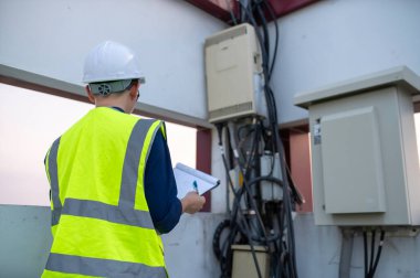 Telekomünikasyon mühendisleri 5G cep telefonu sinyalleri için baz istasyonlarında çalışıyorlar.