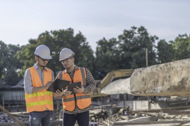 Nehir kıyısındaki bir köprü inşaatında inşaat mühendisi inşaat mühendisi, inşaat denetçisi, Foreman inşaat sahasında çalışıyor, teknik sorunları birlikte tartışıyorlar.