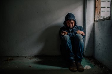 Asyalı bir bağımlı, ıssız bir yerde uyuşturucu bağımlısı, bu dünyada kendini yalnız hisseden bir keş, odanın bir köşesinde oturan üzgün bir genç, insanlar stresli ve depresyondalar.