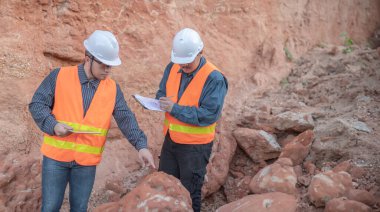 Benimkini araştıran bir jeolog, madenciler mineralleri aramak için toprak örnekleri topluyor..