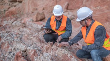 Benimkini araştıran bir jeolog, madenciler mineralleri aramak için toprak örnekleri topluyor..