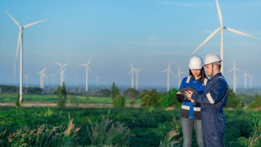 Tayland 'da, dağdaki rüzgar türbini çiftliği güç jeneratörü istasyonunda çalışan mühendisler ve çalışan mühendisler, teknisyen erkek ve kadın iş hakkında tartışıyorlar.