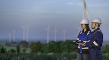 Tayland 'da, dağdaki rüzgar türbini çiftliği güç jeneratörü istasyonunda çalışan mühendisler ve çalışan mühendisler, teknisyen erkek ve kadın iş hakkında tartışıyorlar.