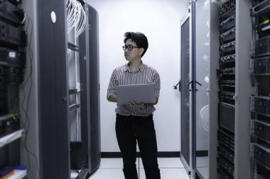 Bilgisayar mühendisi sunucu odasında ağ kuruyor, Sistem Bakım teknisyeni, erkek mühendis modern veri merkezinde sunucu odasında çalışıyor.