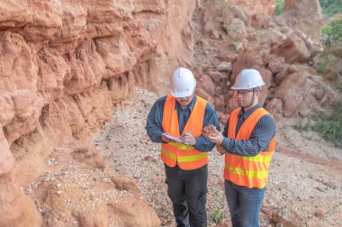 Benimkini araştıran bir jeolog, madenciler mineralleri aramak için toprak örnekleri topluyor..