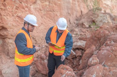 Benimkini araştıran bir jeolog, madenciler mineralleri aramak için toprak örnekleri topluyor..