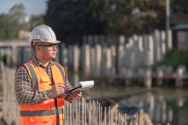 Köprü inşaatında çalışan inşaat mühendisi inşaat mühendisi, inşaat mühendisi denetleme işi, Foreman inşaat sahasındaki işi denetliyor.
