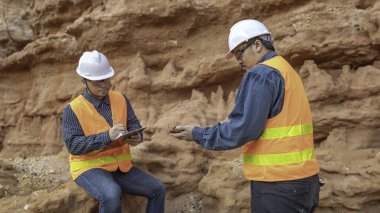 Benimkini araştıran bir jeolog, madenciler mineralleri aramak için toprak örnekleri topluyor..
