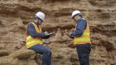 Benimkini araştıran bir jeolog, madenciler mineralleri aramak için toprak örnekleri topluyor..