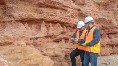Benimkini araştıran bir jeolog, madenciler mineralleri aramak için toprak örnekleri topluyor..