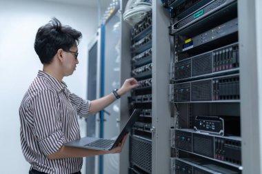 Bilgisayar mühendisi sunucu odasında ağ kuruyor, Sistem Bakım teknisyeni, erkek mühendis modern veri merkezinde sunucu odasında çalışıyor.