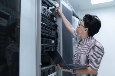 Bilgisayar mühendisi sunucu odasında ağ kuruyor, Sistem Bakım teknisyeni, erkek mühendis modern veri merkezinde sunucu odasında çalışıyor.