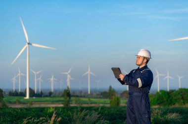 Tayland 'da, dağdaki rüzgar türbini çiftliği güç jeneratörü istasyonunda çalışan mühendisler ve çalışan mühendisler, teknisyen erkek ve kadın iş hakkında tartışıyorlar.
