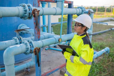 Çevre mühendisleri atık su arıtma tesislerinde çalışıyor. Su ikmali yapan kadın tesisatçı teknisyen.