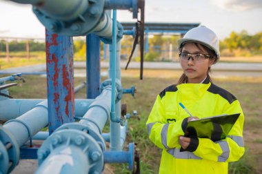 Çevre mühendisleri atık su arıtma tesislerinde çalışıyor. Su ikmali yapan kadın tesisatçı teknisyen.