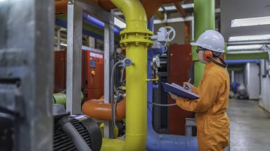 Bir ısıtma tesisinde bakım teknisyeni, Petrokimya işçileri fabrikadaki gaz ve petrol boru hatlarının işleyişini denetliyor, mühendisler işitme koruyucularını birçok boruyla aynı odaya koyuyorlar.