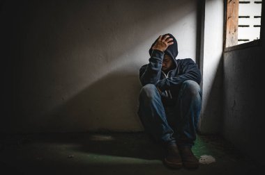 Asyalı bir bağımlı, ıssız bir yerde uyuşturucu bağımlısı, bu dünyada kendini yalnız hisseden bir keş, odanın bir köşesinde oturan üzgün bir genç, insanlar stresli ve depresyondalar.