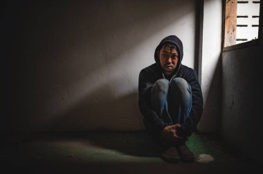 Asyalı bir bağımlı, ıssız bir yerde uyuşturucu bağımlısı, bu dünyada kendini yalnız hisseden bir keş, odanın bir köşesinde oturan üzgün bir genç, insanlar stresli ve depresyondalar.