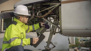 Teknisyen uçağın motorunu tamir ediyor, kadın uzay mühendisliği uçak motorlarını kontrol ediyor, Asyalı tamirci uçak motorlarını kontrol ediyor.