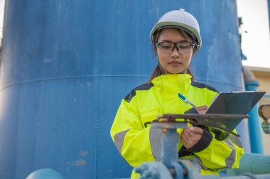 Çevre mühendisleri atık su arıtma tesislerinde çalışıyor. Su ikmali yapan kadın tesisatçı teknisyen.