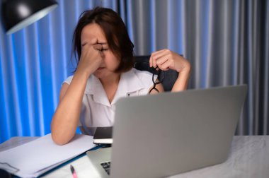 Güzel Asyalı kadın gece evde çalışıyor, şirketten bir sürü iş, eve iş getiriyor, ev konseptinden çalışıyor, sıkı çalışmaktan yorulmuş.