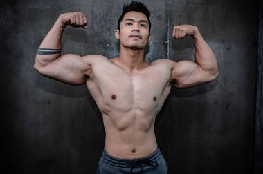 Asyalı bir adamın portresi spor salonundaki büyük kaslar Tayland 'daki insanlar, sağlıklı vücut geliştirme, vücut ağırlığı eğitimi, spor salonundaki spor konsepti.