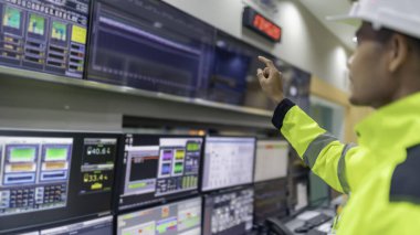 Kontrol odasında çalışan mühendis, yönetici kontrol sistemi, birçok monitörden teknisyen izleme programı.