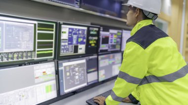 Kontrol odasında çalışan mühendis, yönetici kontrol sistemi, birçok monitörden teknisyen izleme programı.