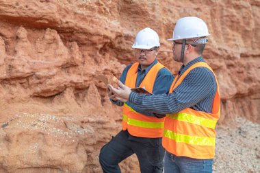 Benimkini araştıran bir jeolog, madenciler mineralleri aramak için toprak örnekleri topluyor..