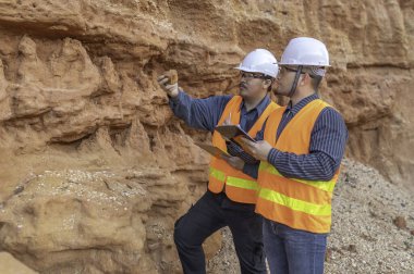 Benimkini araştıran bir jeolog, madenciler mineralleri aramak için toprak örnekleri topluyor..