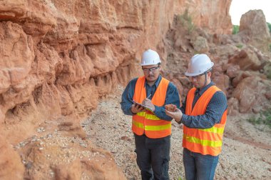 Benimkini araştıran bir jeolog, madenciler mineralleri aramak için toprak örnekleri topluyor..