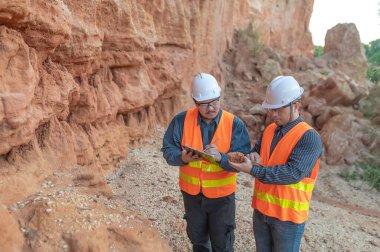 Benimkini araştıran bir jeolog, madenciler mineralleri aramak için toprak örnekleri topluyor..