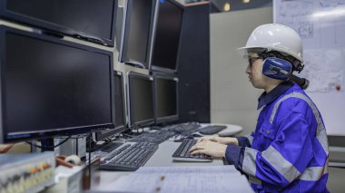 Tayland 'da, ameliyathanede çalışan Asyalı mühendis kask takıyor, özenle ve sabırla çalışıyor, hidrojen tankının valf düzenleyicisini kontrol ediyor..