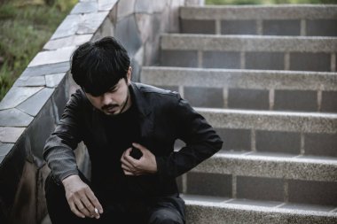 Asyalı bir adam sigara içtiği için hasta. Sigara içtiği için kalp hastası. Dünya tütün günü konsepti yok.