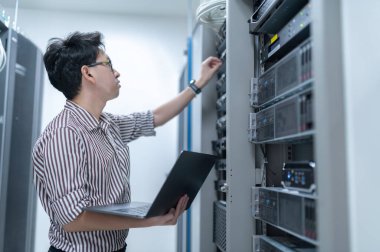 Bilgisayar mühendisi sunucu odasında ağ kuruyor, Sistem Bakım teknisyeni, erkek mühendis modern veri merkezinde sunucu odasında çalışıyor.