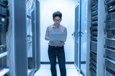 Bilgisayar mühendisi sunucu odasında ağ kuruyor, Sistem Bakım teknisyeni, erkek mühendis modern veri merkezinde sunucu odasında çalışıyor.