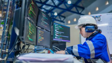 Tayland 'da, ameliyathanede çalışan Asyalı mühendis kask takıyor, özenle ve sabırla çalışıyor, hidrojen tankının valf düzenleyicisini kontrol ediyor..