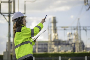 Petrol ve gaz rafinerisi fabrikasında çalışan Asyalı kadın petrokimya mühendisi elektrik santrali enerji imalatında çalışan insan işçi mühendisi.