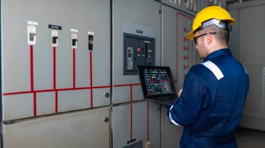 Elektrik mühendisleri ve teknisyenleri endüstriyel kontrol odalarındaki elektrik sistemi arızalarını çözmek için birlikte çalışıyorlar..