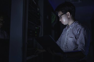 Bilgisayar mühendisi sunucu odasında ağ kuruyor, Sistem Bakım teknisyeni, erkek mühendis modern veri merkezinde sunucu odasında çalışıyor.