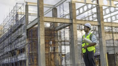 Büyük bir inşaat projesinin şantiyesinde çalışan iki Asyalı mühendis inşaat alanında fazla mesai, inşaat alanındaki mühendis diski, mimar, yönetici ve ustabaşı tasarımı tartışmak için bir araya geldiler.